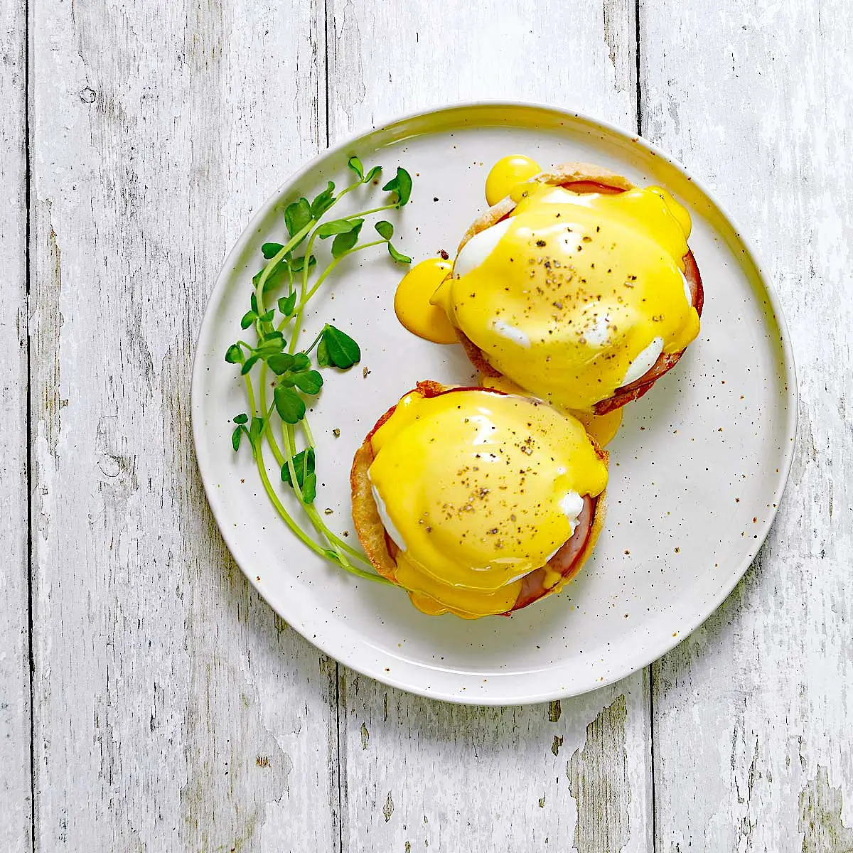 Eggs benedict with greens and hollandaise