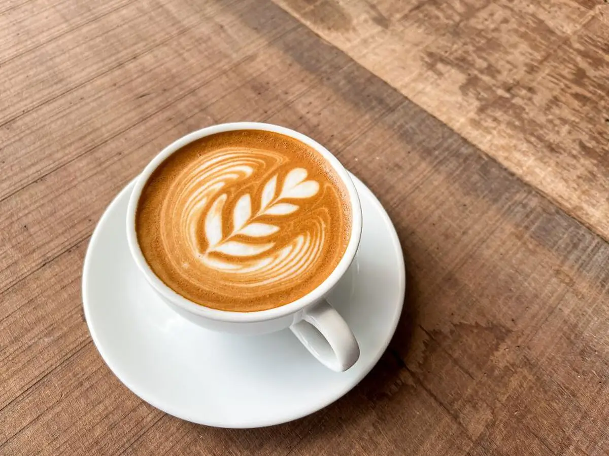Latte with leaf-shaped latte art in a white cup